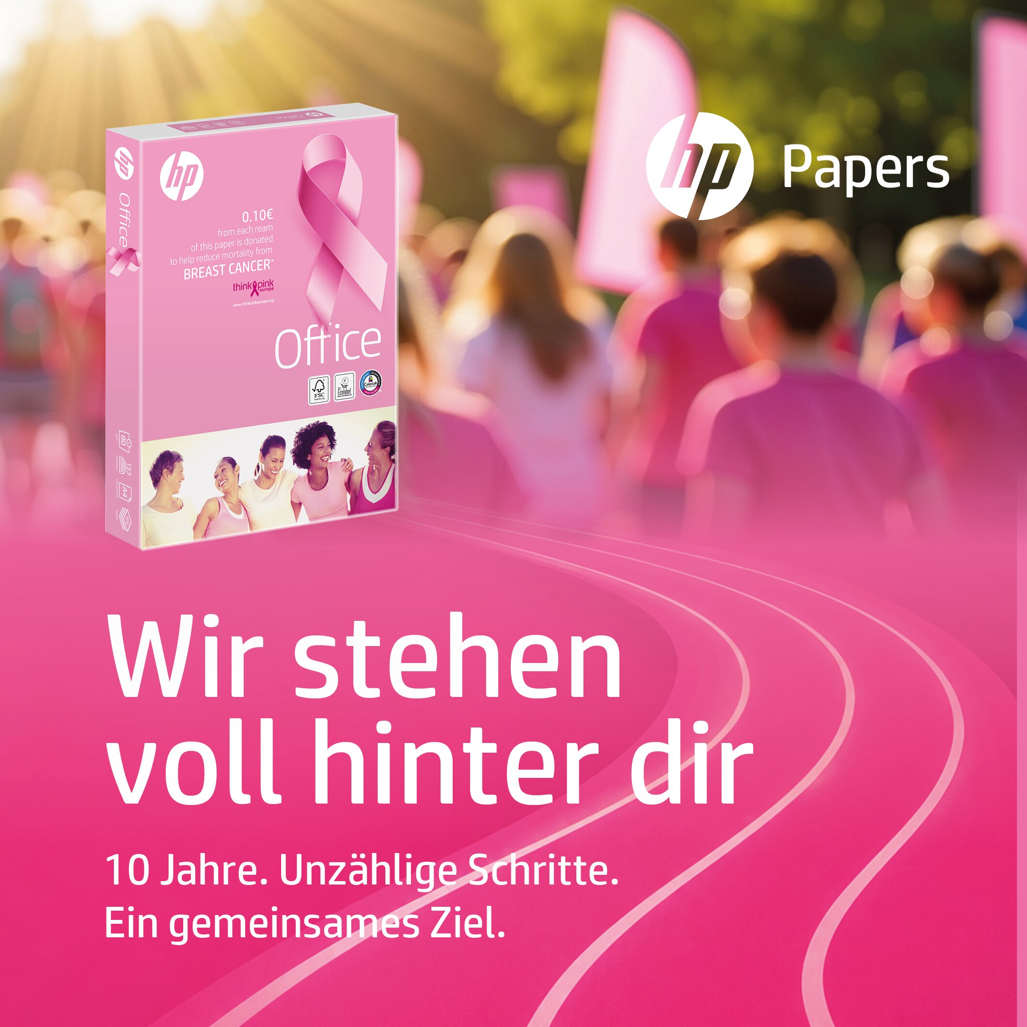 Packung HP Office Pink Ream im Vordergrund, dahinter mehrere Frauen in pinker Sportkleidung auf einer Laufbahn. Text: 2Wir stehen voll hinter dir. 10 Jahre. Unzählige Schritte. Ein gemeinsames Ziel.