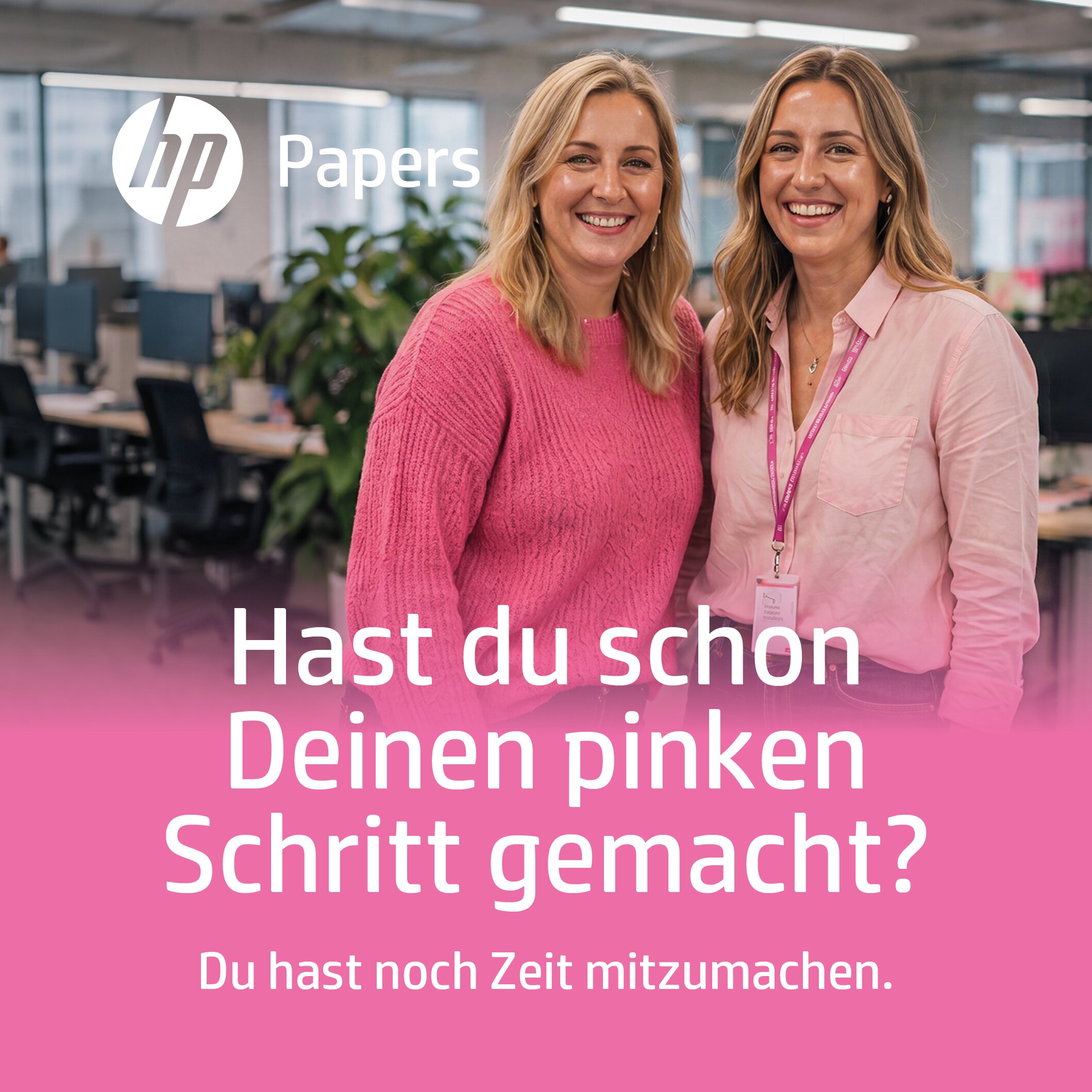 Zwei lachende Frauen in pinker Kleidung stehen gemeinsam in einem Büro. Text: "Hast du schon Deinen pinken Schritt gemacht? Du hast noch Zeit mitzumachen."